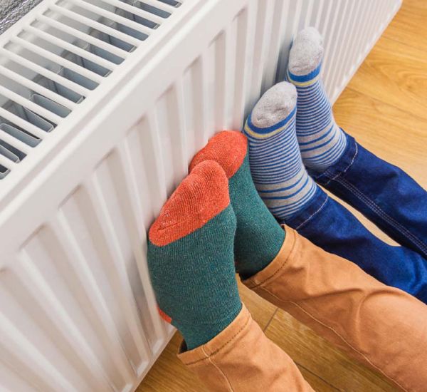 Close shot of feet with socks leaning on a heater