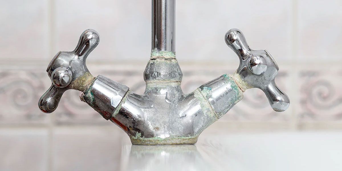 Close-up of a faucet featuring two handles, showcasing its sleek design and polished finish.